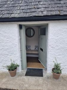 una entrada a una casa blanca con un sofá en la puerta en North Coast Property - 17 Margaret Street - Avoch en Avoch