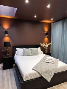 1 dormitorio con 1 cama grande con sábanas y almohadas blancas en Sky City Apartments en Coventry