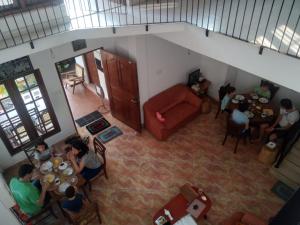 a group of people sitting at tables in a living room at Villu Villa in Anuradhapura