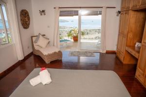a living room with a couch and a chair and a window at Beau Soleil Stunning Sea View One Bedroom Apartment in Mahe