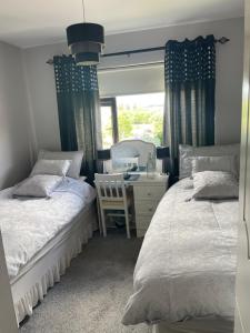 a bedroom with two beds and a desk and a mirror at Bru Na Pairc B&B in Bantry