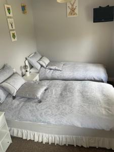 a bedroom with two beds with white sheets at Bru Na Pairc B&B in Bantry