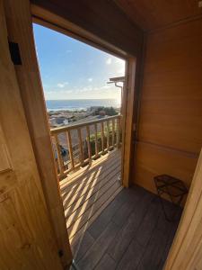 um quarto com uma varanda com vista para o oceano em Hostal F em El Quisco