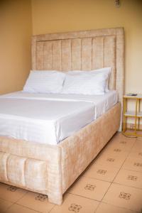 een bed met een groot hoofdeinde in een kamer bij Clarine Cozy Holiday Home in Mtwapa