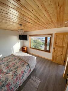 - une chambre avec un lit et une grande fenêtre dans l'établissement Hostal F, à El Quisco