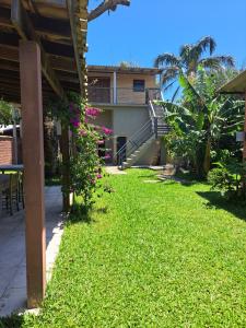 a yard with a building with stairs and pink flowers at Sobrado com vista profissional do mar in Arroio do Sal