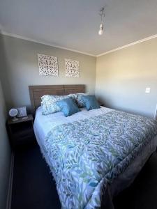 um quarto com uma cama grande e lençóis azuis em Acogedor hogar en Rinconada de los Andes em Rinconada de los Andes