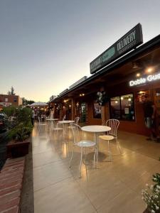 uma fila de mesas e cadeiras fora de um restaurante em Acogedor hogar en Rinconada de los Andes em Rinconada de los Andes