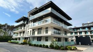 ポゴジェリツァにあるSea View Pogorzelica Szeroka Spokojna Plaża z widokiem na morzeのたくさんの窓がある大きな白い建物