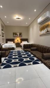 a room with two beds and a blue and white rug at كوخ الشاطئ جمال الحاضر والطبيعة in Jazan