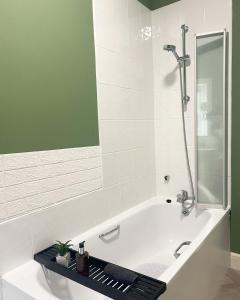 a bathroom with a bath tub with a shower at Anfield city break in Liverpool