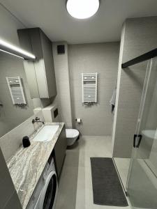 ポゴジェリツァにあるSea View Pogorzelica Szeroka Spokojna Plaża z widokiem na morzeの洗面台と洗濯機を備えたバスルーム +10枚の写真