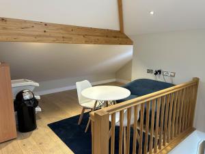 um quarto com uma mesa e uma escada com uma mesa e cadeiras em Immaculate 1-Bed Apartment in Penzance em Penzance