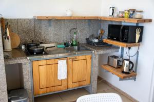 a small kitchen with a sink and a microwave at Beau Soleil Stunning Sea View One Bedroom Apartment in Mahe