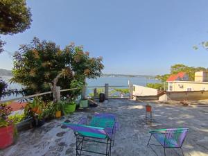 een patio met stoelen en uitzicht op het water bij Casa Zoila Hospedaje frente al lago Lakefront lodging in Flores