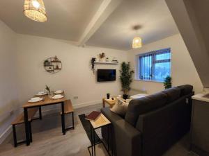 ApartHotel Flat 7: Keyless Entry. 10 min to centre by Property Promise في كارديف: غرفة معيشة مع أريكة وطاولة