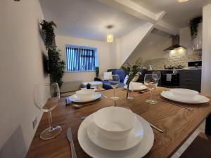 ApartHotel Flat 7: Keyless Entry. 10 min to centre by Property Promise في كارديف: طاولة طعام مع أطباق وأكواب نبيذ عليها