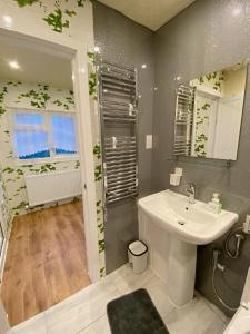 a bathroom with a white sink and a mirror at Barking London House sleeps 11 - parking - train tube - airport in London