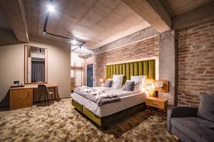 um quarto com uma cama grande e uma parede de tijolos em Mustang Boutique Rooms em Oradea