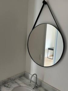 a mirror hanging above a sink in a bathroom at Studio ao lado Allianz parque in Sao Paulo