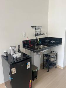 a kitchen with a black refrigerator and a sink at Studio ao lado Allianz parque in Sao Paulo