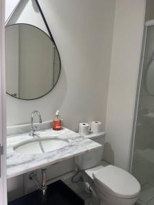 W łazience znajduje się umywalka, toaleta i lustro. w obiekcie Studio ao lado Allianz parque w São Paulo