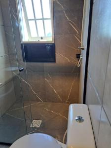 a bathroom with a shower with a toilet and a window at Sobrado com vista profissional do mar in Arroio do Sal