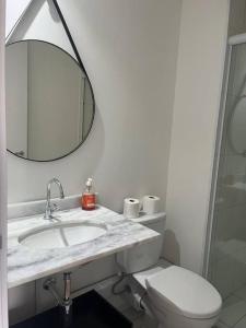a bathroom with a sink and a toilet and a mirror at Studio ao lado Allianz parque in São Paulo