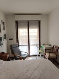 een slaapkamer met een bed en stoelen en een bureau bij La casetta a Gorgonzola in Gorgonzola