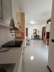 een keuken en een woonkamer met een witte vloer bij La casetta a Gorgonzola in Gorgonzola