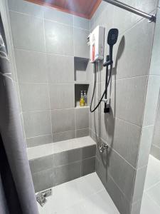 a shower stall with a hair dryer in a bathroom at Villa Lourdes in Alaminos