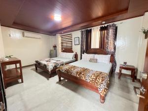 a bedroom with two beds and a table at Villa Lourdes in Alaminos