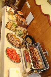 uma mesa com muitos tipos diferentes de alimentos sobre ele em Hotel Marija em Kotor