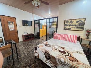 a bedroom with a bed with a desk and a dresser at Villa Lourdes in Alaminos