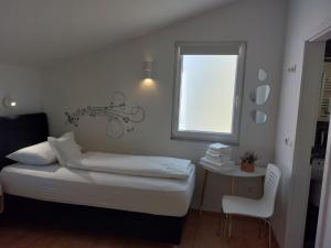 niewielka sypialnia z łóżkiem i oknem w obiekcie App Lux F w Makarskiej