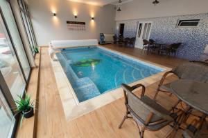 バイレ・フェリクスにあるComplex Turistic Monacoのテーブルと椅子付きの客室内のスイミングプールを利用できます。