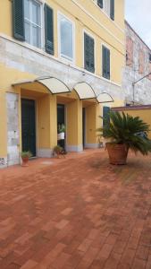 a yellow building with a courtyard with potted plants at CriLo Pisa in Pisa