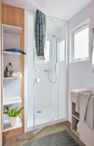 een badkamer met een douche en een glazen deur bij Camping La Forêt Stella-Plage in Stella-Plage