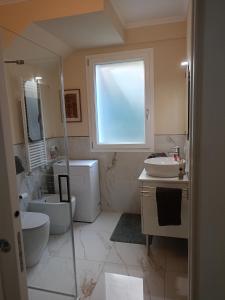 een badkamer met een wastafel en een toilet en een raam bij Il nido di Ele in Stresa