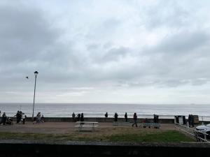 eine Gruppe von Menschen, die am Strand entlang gehen in der Unterkunft The Beach House in Edinburgh