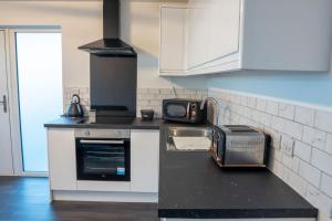 a kitchen with a stove and a toaster on a counter at The Porty Beach House in Edinburgh +1 photo