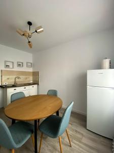 a kitchen with a table and chairs and a refrigerator at B residence - Apartment A in Iaşi