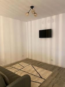 a living room with a couch and a television on a wall at B residence - Apartment A in Iaşi