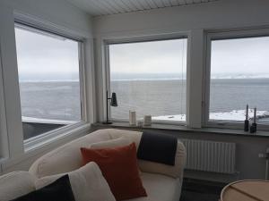 a living room with a white couch and windows at The Black House Tuapannguit 48 in Nuuk