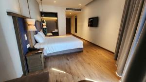 a hotel room with a bed and a television at Apec Mandala Mũi Né in Ấp Long Sơn