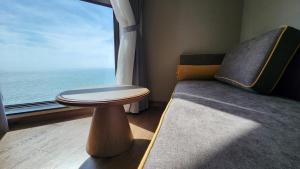 a room with a bed and a window with a table at Apec Mandala Mũi Né in Ấp Long Sơn