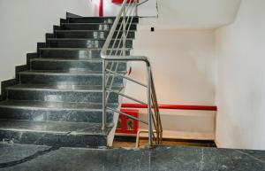 a staircase in a building with a metal railing at Super Townhouse 412 Aditya International in Bhubaneshwar