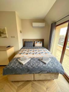 een groot bed in een kamer met een groot raam bij Azurro Residence in Sofia