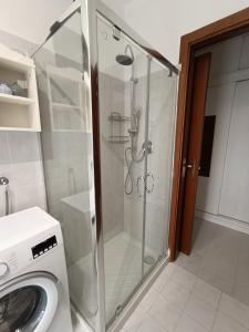 een douche in een badkamer met een wasmachine bij La casetta a Gorgonzola in Gorgonzola