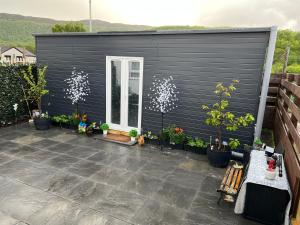 czarna szopa z doniczkami na patio w obiekcie Craigellachie Cabin w Aviemore